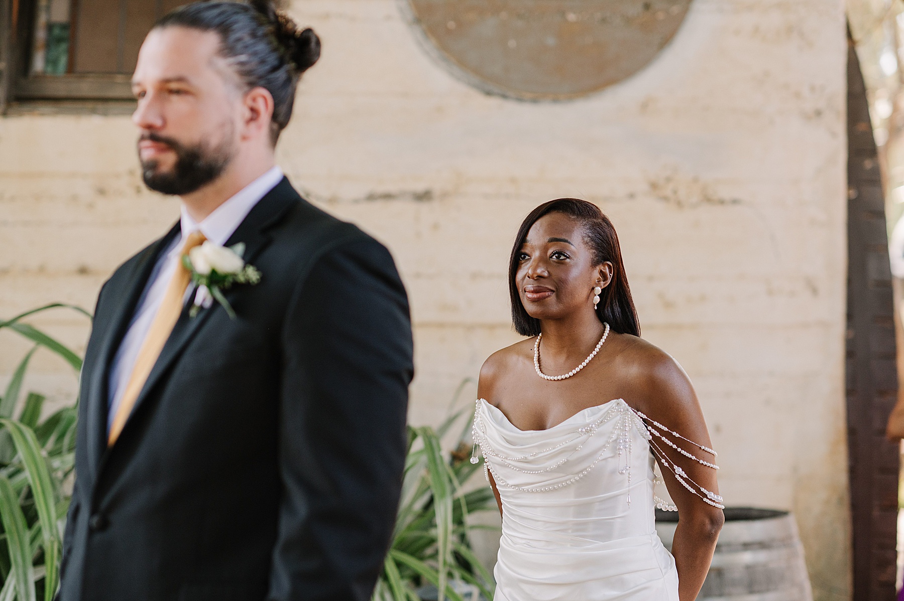 Heartwarming first look at Harmony California wedding venue, with the bride radiating elegance in her pearl-accented gown as she approaches the groom.