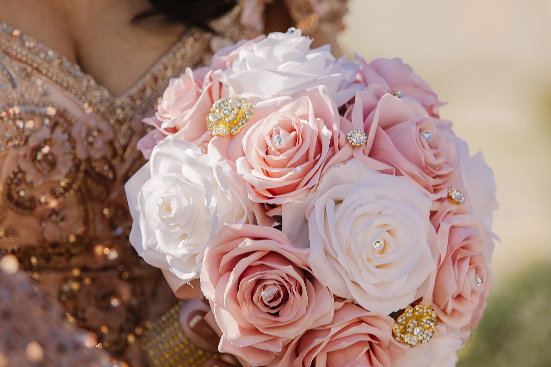 A close-up of Mary Luz’s stunning bouquet at her Tooth + Nail Winery Quinceañera, featuring delicate pink and white roses adorned with sparkling golden accents.