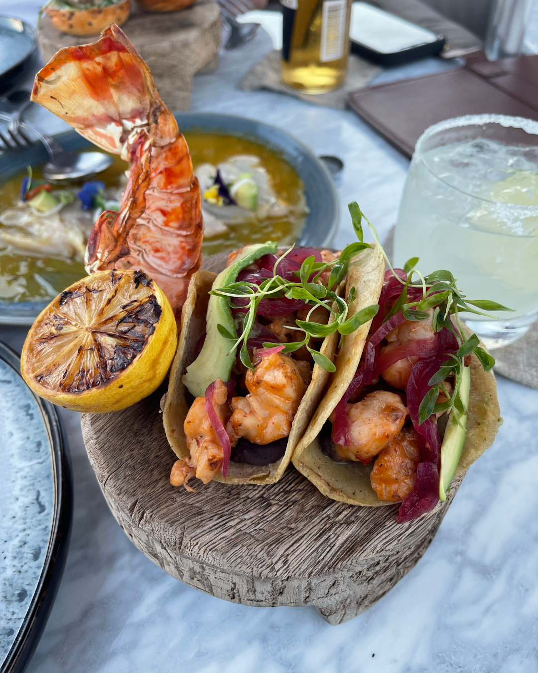 Delicious shrimp tacos with grilled lemon and a margarita in Cabo San Lucas.