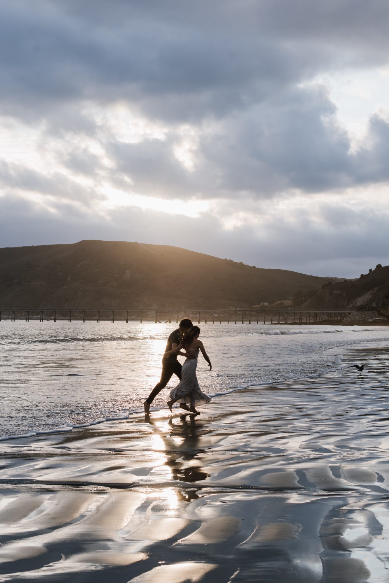 Man and Woman running on the beach at sunset