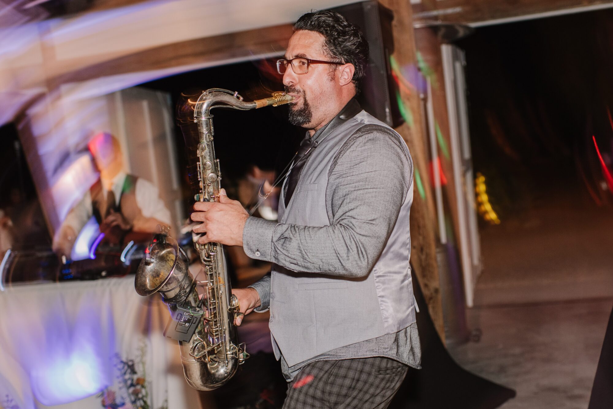 Live saxophonist performing at a vibrant wedding reception, showcasing unique entertainment trends for 2025 weddings.